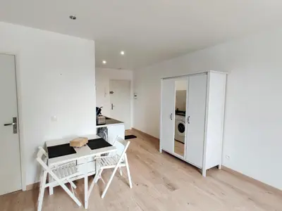 a white room with a table and chairs and a washing machine at Le Nid du Pont Neuf in Pamiers