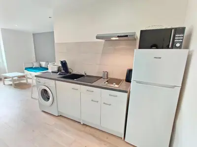 a kitchen with a refrigerator and a washing machine at Le Nid du Pont Neuf in Pamiers