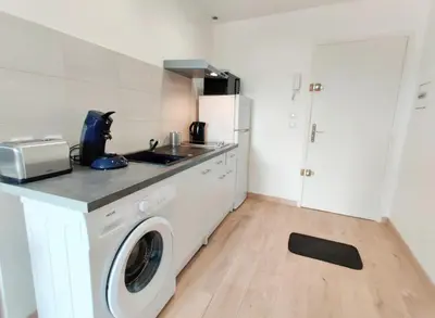a kitchen with a sink and a washing machine at Le Nid du Pont Neuf in Pamiers
