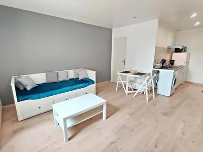 a white room with a bed and a table at Le Nid du Pont Neuf in Pamiers