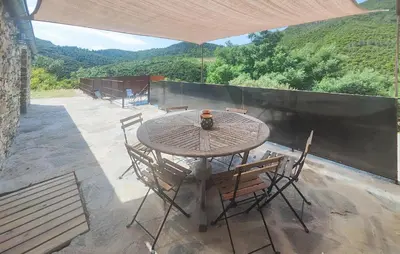 a wooden table and chairs on a patio at 3 Bedroom Stunning Home In Vieussan in Vieussan
