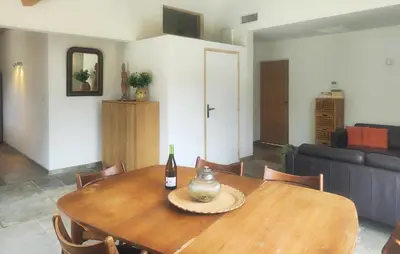 a dining room table with a bottle of wine on it at 3 Bedroom Stunning Home In Vieussan in Vieussan