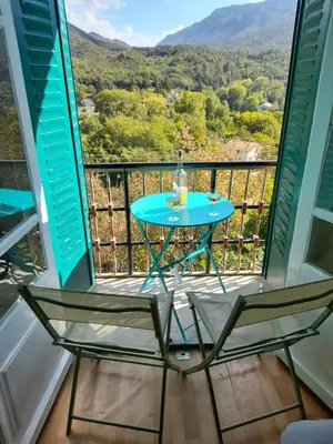 a table and chairs on a balcony with a view at Les Citronniers in Belvianes-et-Cavirac