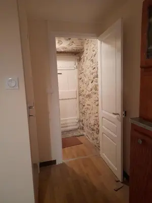 a hallway with a door and a stone wall at Les Citronniers in Belvianes-et-Cavirac