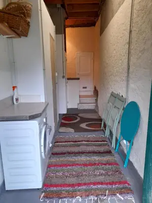 an empty hallway with a rug and a washing machine and chairs at Les Citronniers in Belvianes-et-Cavirac