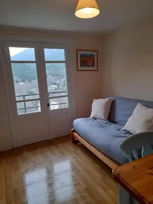 a living room with a couch and a window at Les Citronniers in Belvianes-et-Cavirac