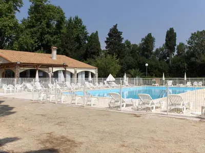 a row of white chairs next to a swimming pool at VVF Sigean Port-la-Nouvelle Corbières in Sigean