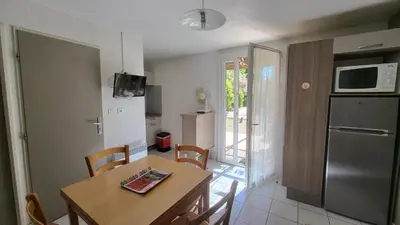 a kitchen and dining room with a table and chairs at VVF Sigean Port-la-Nouvelle Corbières in Sigean