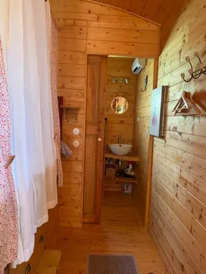 a bathroom with a sink in a log cabin at La roulotte de Plajoulet in Mirepoix