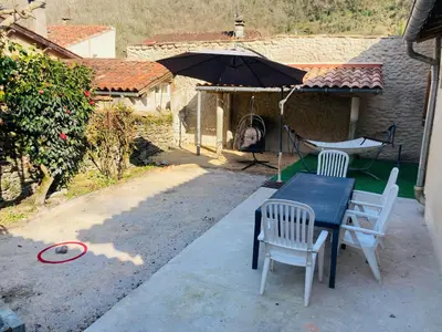 a table and chairs and an umbrella on a patio at Gite centre village Burlats in Burlats