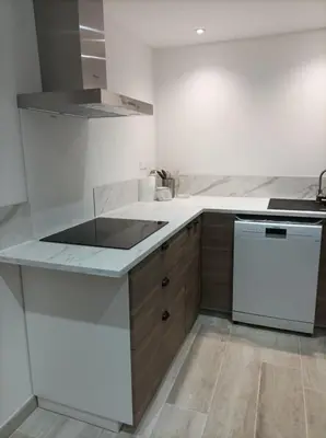 a white kitchen with a stove and a dishwasher at Gite centre village Burlats in Burlats