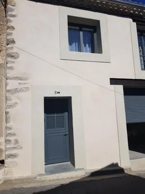 a white building with a blue door and a window at Maison Stellas in Fontiès-dʼAude