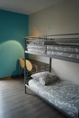 a room with three bunk beds and a chair at Centre International de Séjour - MJC in Lézignan-Corbières