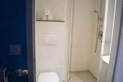 a white bathroom with a toilet and a sink at Centre International de Séjour - MJC in Lézignan-Corbières