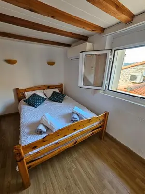 a bed in a small room with a window at Gîtes Tautavel in Tautavel