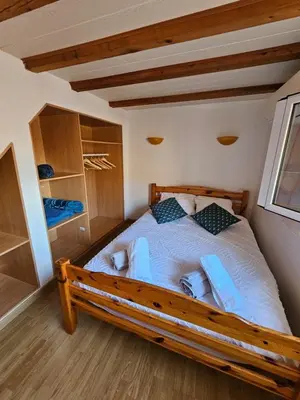 a bedroom with a wooden bed in a room at Gîtes Tautavel in Tautavel