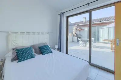 a bedroom with a white bed and a sliding glass door at Gîtes Tautavel in Tautavel