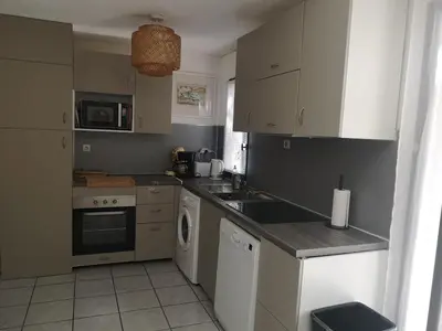a kitchen with a sink and a dishwasher at Maison avec jardin clos dans residence in Gruissan