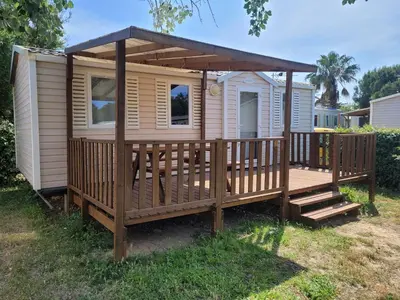 a cabin with a porch and a deck at mobile home climatisé, 3 chambres in Port-la-Nouvelle