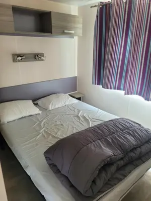 a large bed in a bedroom with at mobile home climatisé, 3 chambres in Port-la-Nouvelle