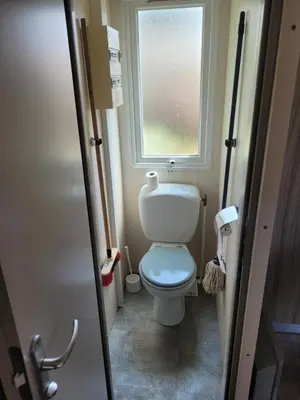 a small bathroom with a toilet and a window at mobile home climatisé, 3 chambres in Port-la-Nouvelle