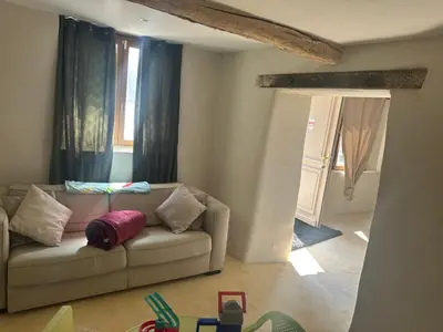 a living room with a couch and a window at Ma petite chaumière in Bouilhonnac
