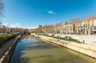 a view of a river in a city with buildings at Le Rive Gauche - Au cœur du centre historique in Narbonne