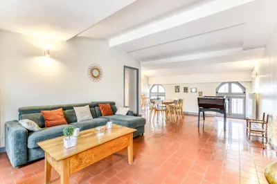 a living room with a couch and a table and a piano at Cocon Carcassonnais - Free parking - Wifi - Climatisation - Tout équipée in Carcassonne