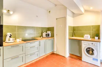 a kitchen with a washing machine and a washer at Cocon Carcassonnais - Free parking - Wifi - Climatisation - Tout équipée in Carcassonne
