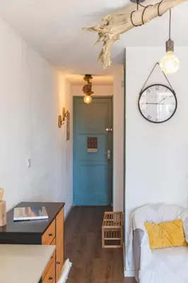 a room with a blue door and a bed and a table at Le Rivage du Nilautom in Gruissan