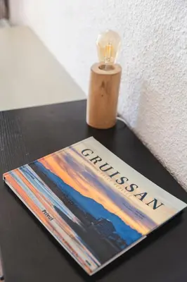 a book and a candle on a table at Le Rivage du Nilautom in Gruissan