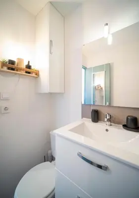 a bathroom with a white sink and a toilet at Le Rivage du Nilautom in Gruissan