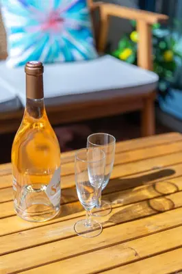a bottle of wine and two glasses on a table at Le Rivage du Nilautom in Gruissan