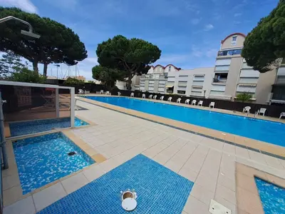 a swimming pool in front of a building at Le Rivage du Nilautom in Gruissan