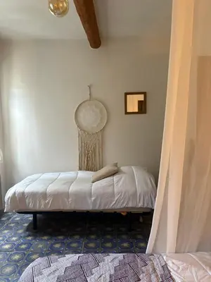 a bedroom with a bed in the corner of a room at CHAMBRE D'HOTE Ô MAZETTE visite de l'Aude in Fabrezan