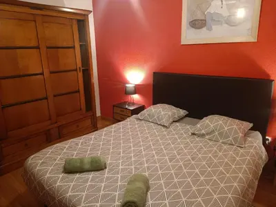 a bedroom with a bed and a red wall at Chambre d'hôtes petit déjeuner compris in Carcassonne