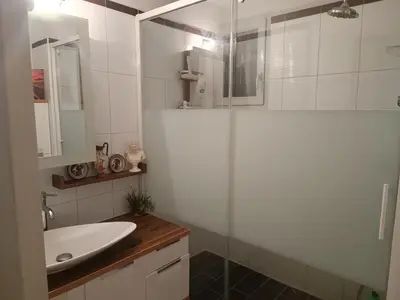 a bathroom with a glass shower and a sink at Chambre d'hôtes petit déjeuner compris in Carcassonne