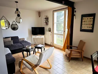 a living room with a couch and a tv at Terrasse, vue & Parking - Carnaval à pied in Limoux