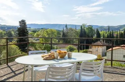 a white table and chairs on a balcony at Terrasse, vue & Parking - Carnaval à pied in Limoux