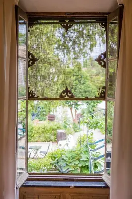 a window with a view of a garden outside at O'MAZETTE CHAMBRE D'HOTE ROMANTIQUE visite de l'aude in Fabrezan