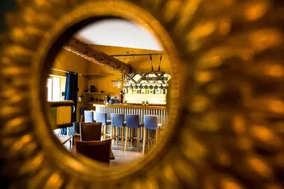 a view of a bar with blue chairs in a room at O'MAZETTE CHAMBRE D'HOTE ROMANTIQUE visite de l'aude in Fabrezan