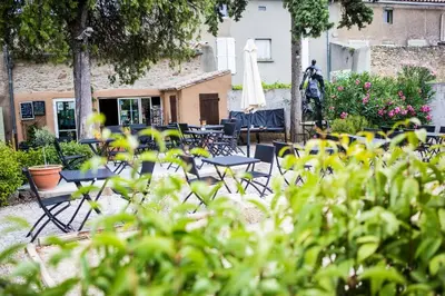a group of chairs and tables in a yard at O'MAZETTE CHAMBRE D'HOTE ROMANTIQUE visite de l'aude in Fabrezan