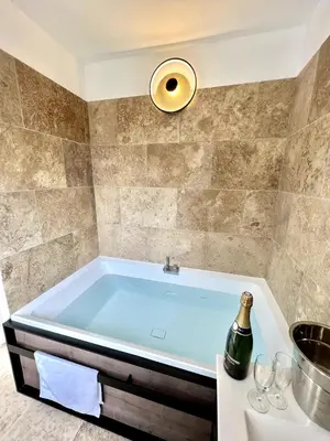 a bath tub in a bathroom with a bottle of champagne at The62 in Carcassonne