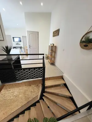 a hallway with a staircase in a house at Maison au calme - Clim - Wi-Fi - terrasse et cours in Salles-d'Aude