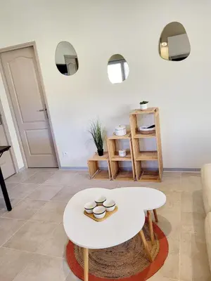 a living room with a white table and a couch at Maison au calme - Clim - Wi-Fi - terrasse et cours in Salles-d'Aude