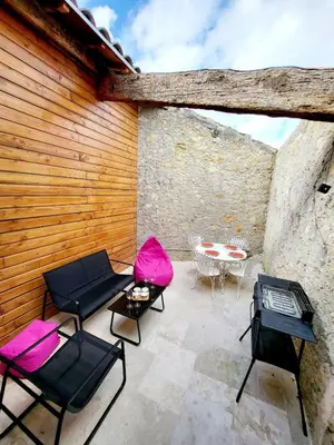 a patio with chairs and a table and a wall at Maison au calme - Clim - Wi-Fi - terrasse et cours in Salles-d'Aude