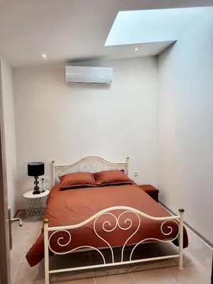 a bedroom with a bed in a white room at Maison au calme - Clim - Wi-Fi - terrasse et cours in Salles-d'Aude