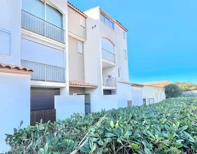 an apartment building with plants in front of it at Lo Nidou Gruissan in Gruissan