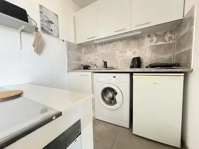 a kitchen with a washer and a washing machine at Lo Nidou Gruissan in Gruissan