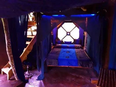a bedroom with a bed in a blue tent at Le Vertige du Tigre in Courniou